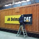 Odborná montáž samolepiacej fólie na technologický kontajner – aplikácia reklamy v priemyselnom prostredí.