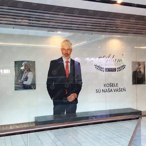 Elegantný polep výkladu predajne Adam košele – biela samolepiaca fólia s logom a grafikou.