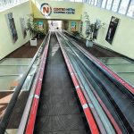 Reklamný polep spodných líšt travelátora v obchodnom centre – biela samolepiaca fólia s potlačou.