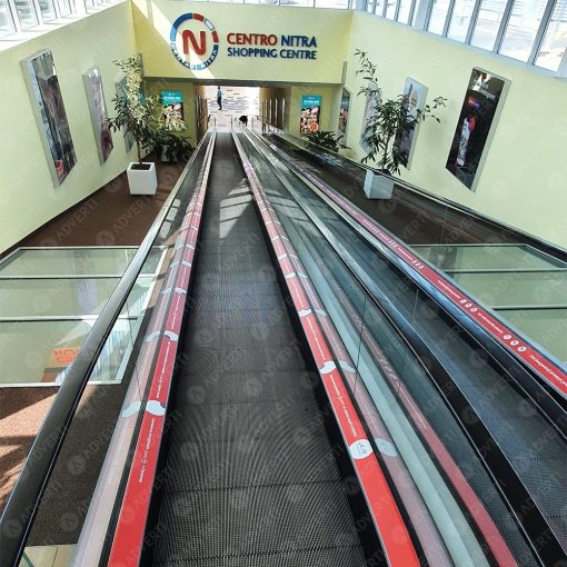 Reklamný polep spodných líšt travelátora v obchodnom centre – biela samolepiaca fólia s potlačou.
