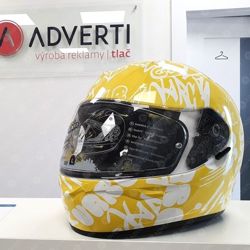 Custom polep motokárskej prilby – detailná aplikácia samolepiacej fólie na 3D povrch.